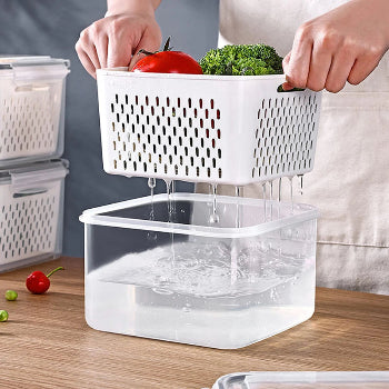 person draining vegetables in clear food storage container with colander insert