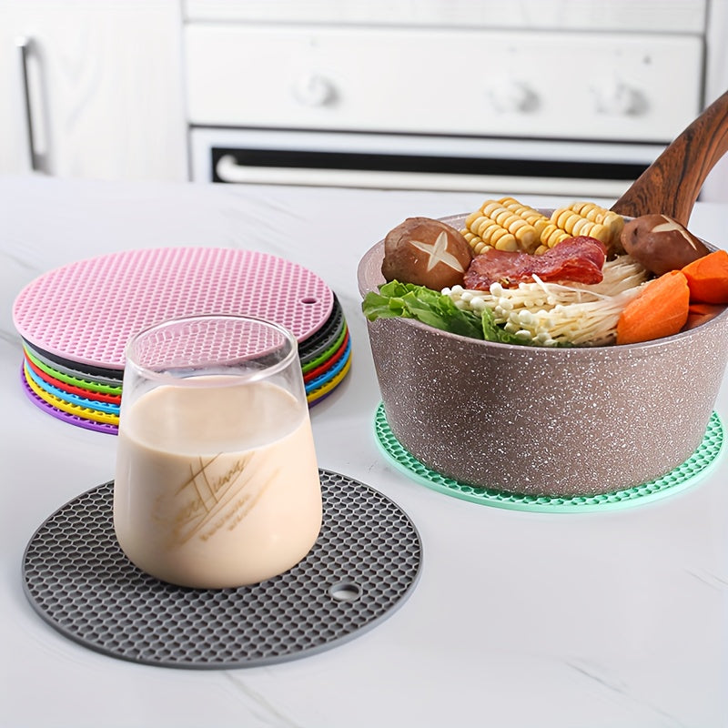 Colorful silicone trivets on a kitchen counter with a glass of milk and a bowl of food.