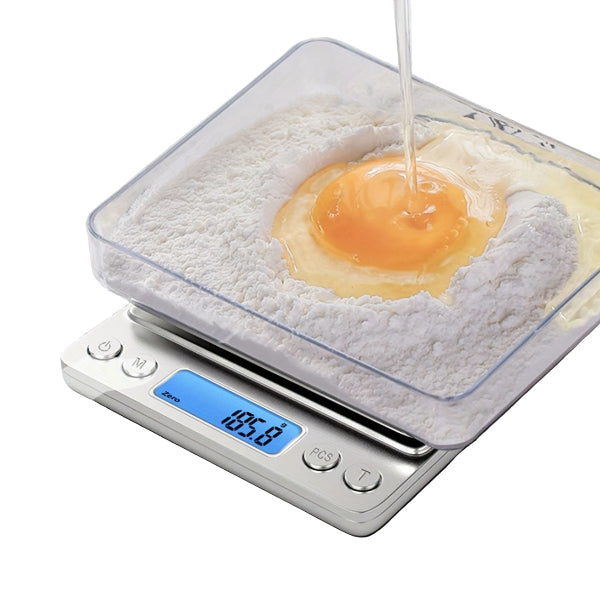 steel kitchen digital scale weighing flour and an egg