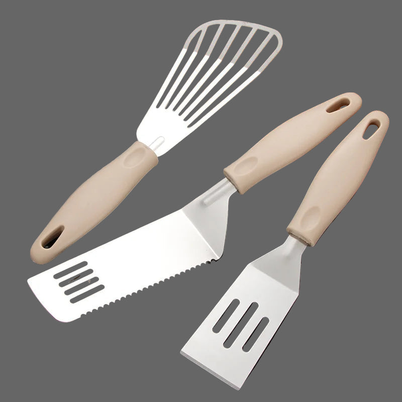 Three food spatulas with beige handles on a dark surface