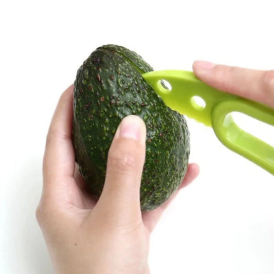 person slicing an avocado with a green slicer