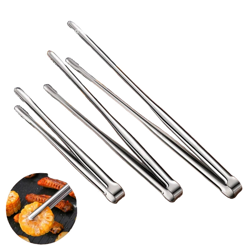 Set of metal tongs on a white surface with food items in the background