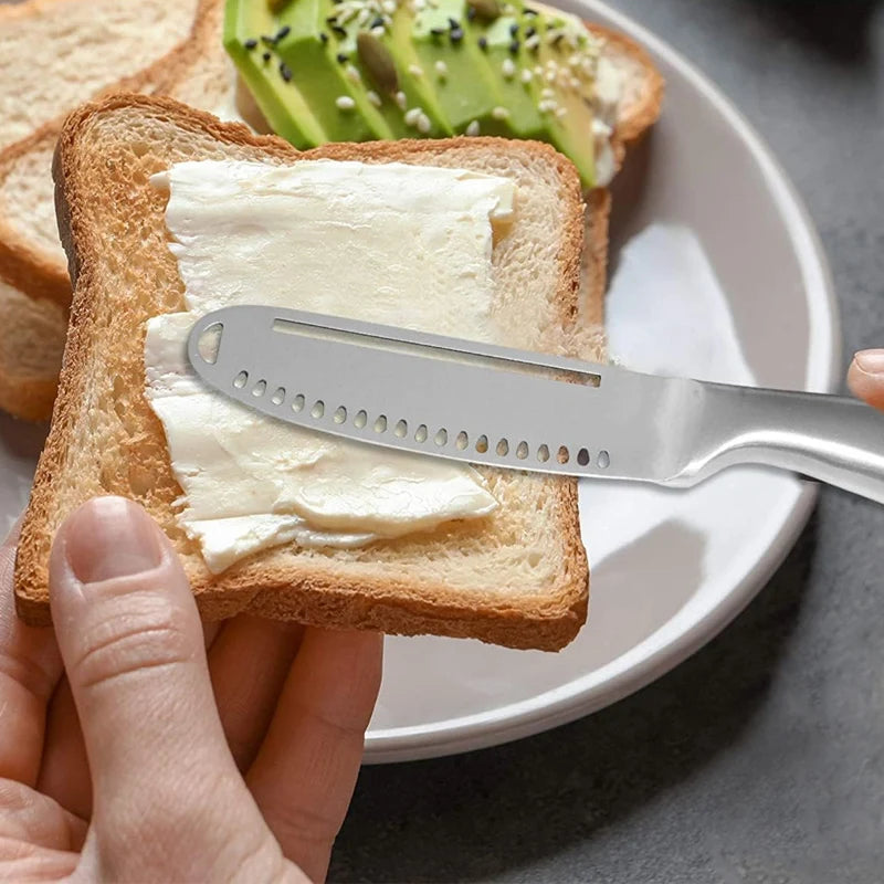 person spreading butter on toast with a stainless steel butter spreader knife