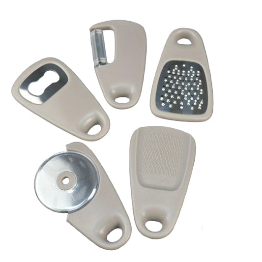 Set of kitchen tools including a bottle opener, grater, and garlic press on a gray surface.