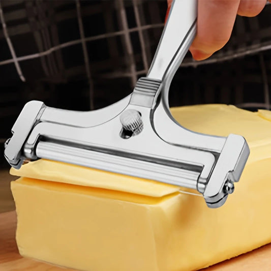 Metal cheese slicer cutting into a block of cheese on a wooden surface.