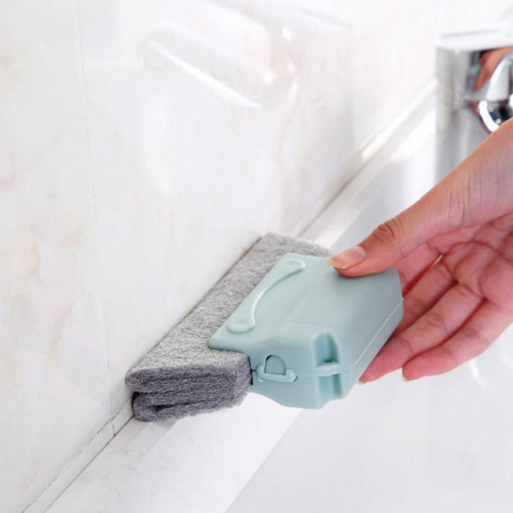 person cleaning a floor edge trim with a blue handle slot cleaner