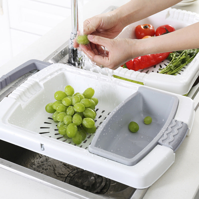 person washing grapes with a white and drainer and grey insert