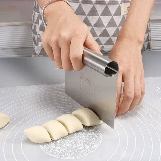 person cutting dough with a steel dough cutter on a grey silicone mat