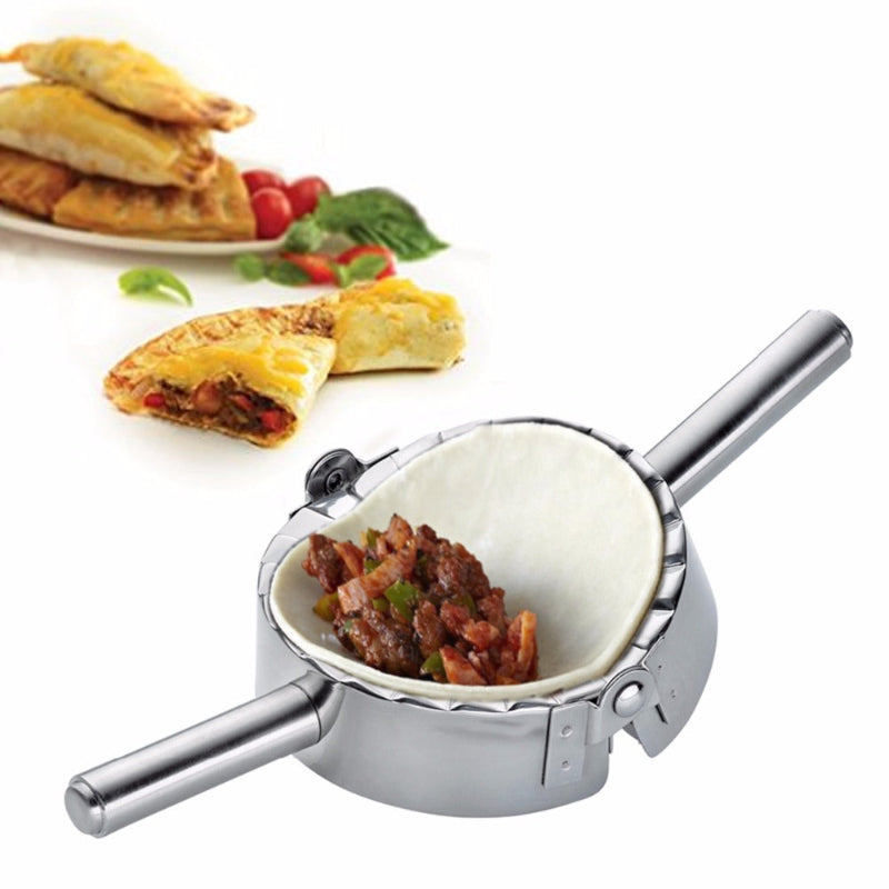 Metallic empanada press with food inside, next to empanadas on a white background