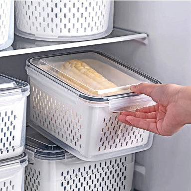 Hand holding a plastic storage container with a lid in a refrigerator.
