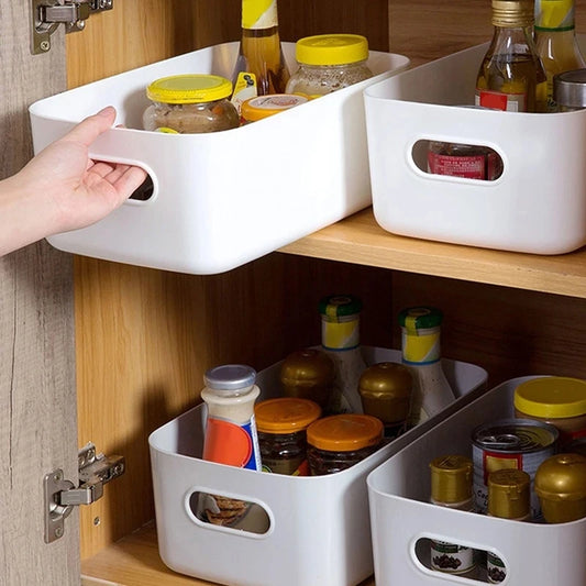 a person sliding out a white kitchen cabinet food storage bin in a kitchen cabinet