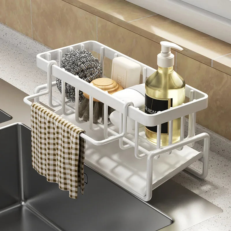 white kitchen sink caddy with cleaning aids and a cloth on a kitchen sink