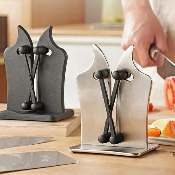Knife sharpener on a kitchen counter with a blurred background of a person cutting vegetables.