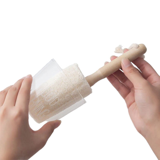 person cleaning a glass with a loofah brush