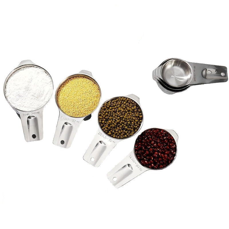 Set of stainless steel measuring cups with various ingredients on a white background