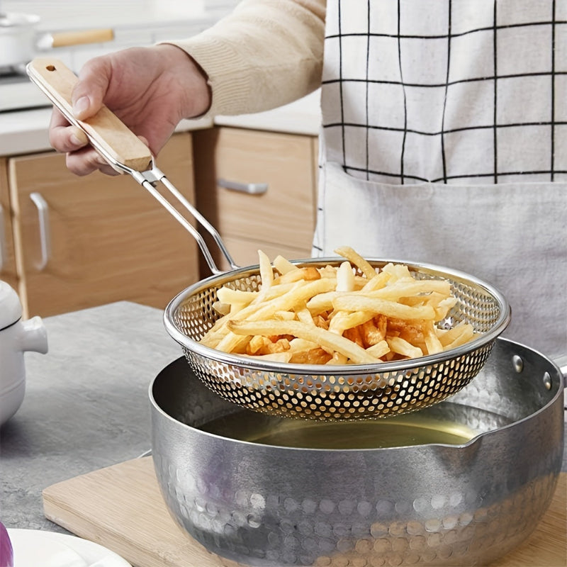 Person draining fried food from a pot using a metal strainer.