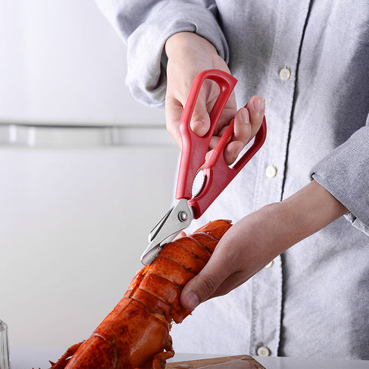 person cutting lobster tail with shellfish scissors