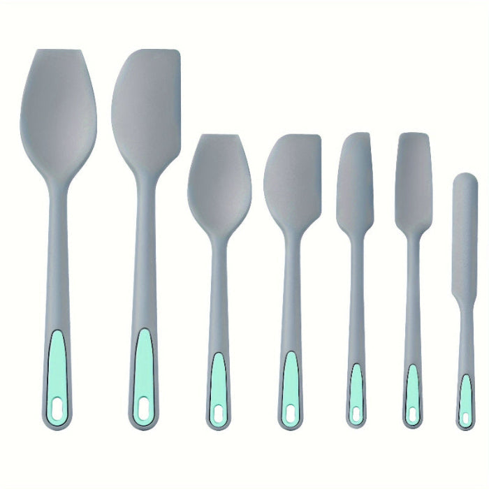 Set of gray spatulas with green handles on a white background
