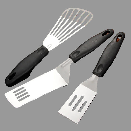 Three kitchen spatulas with black handles on a dark background