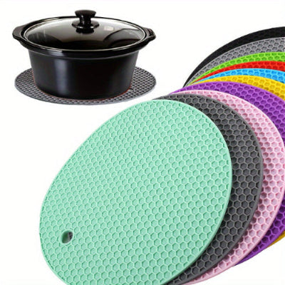 Set of colorful silicone trivets with a black pot on a white background