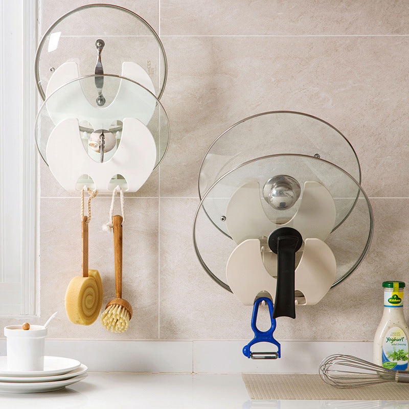 white wall mounted kitchen storage racks with pot lids and utensils