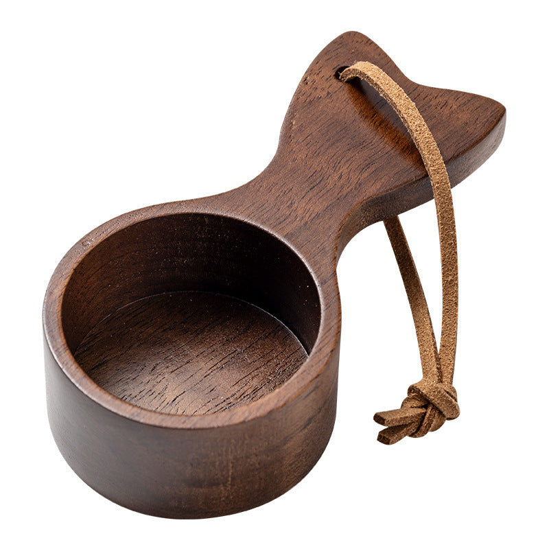 Wooden scoop with leather handle on a white background