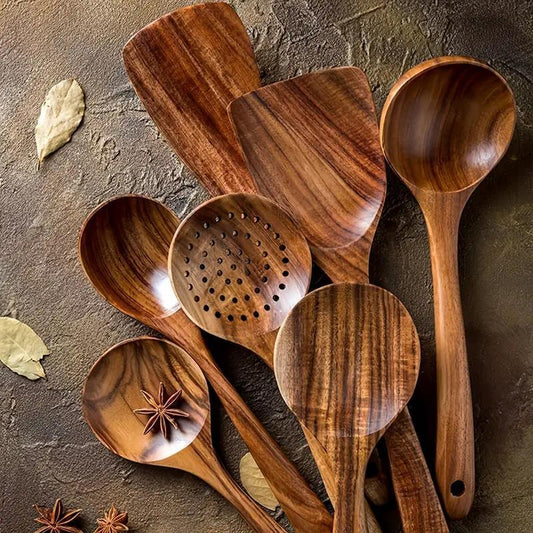 Set of wooden kitchen utensils on a textured surface with leaves and stars.